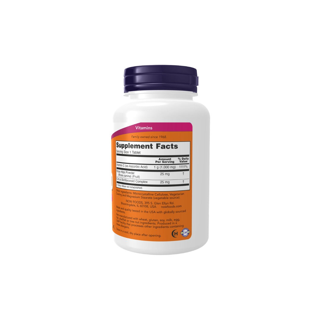 White Now Foods supplement bottle with a pink label displaying Vitamin C-1000 nutritional information isolated on a white background.