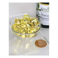 Thumbnail for A small glass bowl holds yellow capsules beside a penny for scale, highlighting their compactness. A 