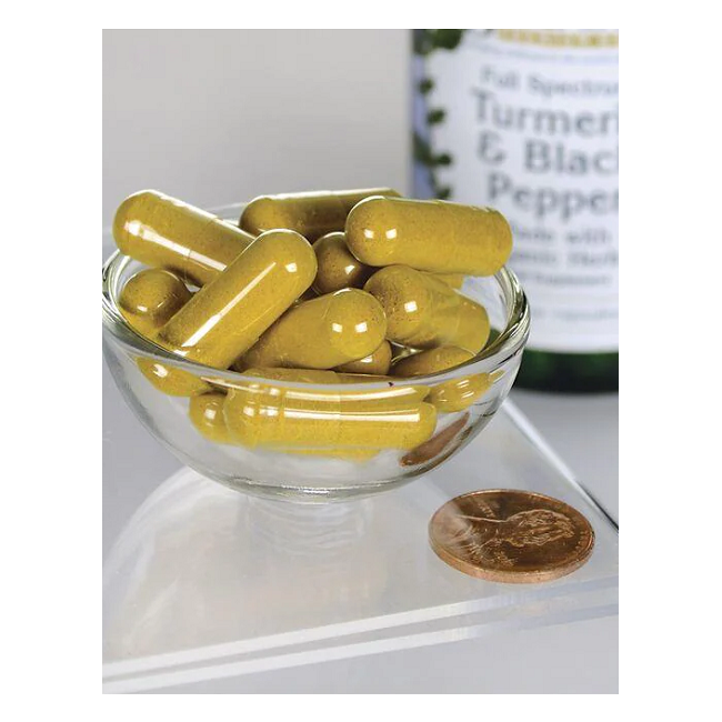 A small glass bowl with yellow capsules beside a penny for scale, and a Swanson "Turmeric & Black Pepper 60 Veggie Capsules" bottle in the background, emphasizing their joint health benefits.