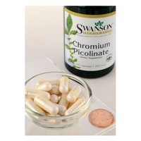 Thumbnail for A small glass bowl holds white capsules beside a bottle labeled 