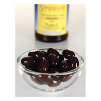 Thumbnail for A glass bowl with dark brown capsules elegantly hints at the natural goodness of Menaquinone-7. In the background, a bottle of Swanson Vitamin K2-MK-7 100 mcg 30 Softgels evokes the traditional Natto source of Vitamin K2.