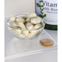 Thumbnail for A glass bowl of Swanson's Vitamin C with Rose Hips - 1000 mg 250 Tablets on a white surface with a bottle labeled 
