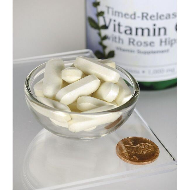 A bottle of Swanson Vitamin C - 1000 mg 250 tabs Timed Release with a penny next to it, promoting immune system health.