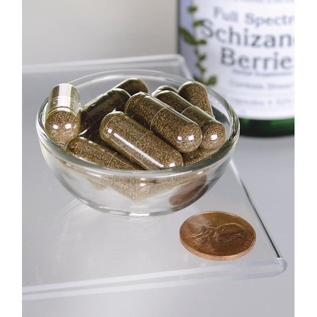 SwansonDie Schizandra-Beeren - 525 mg 90 Kapseln, ein Lebertonikum und Adaptogen, werden in einer Schale neben einem Penny präsentiert.