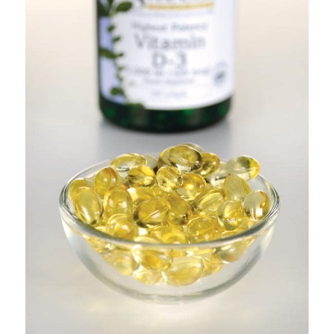 Swanson Vitamin D3 - 5000 IU 250 softgel, essential for immune function and calcium absorption, can be seen in a bowl next to a bottle.