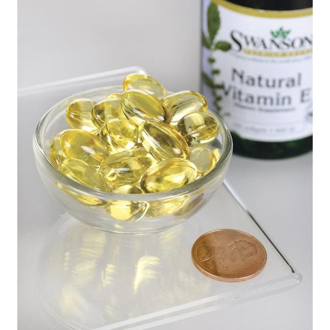 A bottle of Swanson's Vitamin E - Natural 400 IU 100 softgel, known for its antioxidant support and beneficial effects on cardiovascular health, is accompanied by a penny.