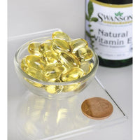 Thumbnail for A bottle of Swanson's Vitamin E - Natural 400 IU 100 softgel, known for its antioxidant support and beneficial effects on cardiovascular health, is accompanied by a penny.