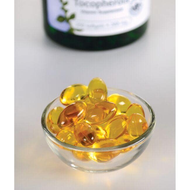 A bowl of Swanson Vitamin E - 400 IU 250 softgel Mixed Tocopherols next to a bottle, promoting cardiovascular health and providing antioxidant support.