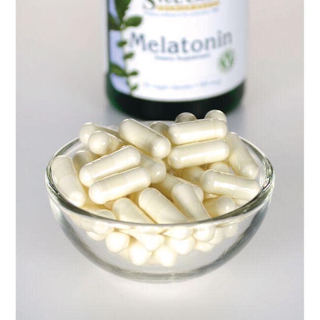 Swanson Melatonin - 0,5 mg 60 pflanzliche Kapseln in einer Glasschale neben einer Flasche.