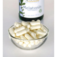 Vorschaubild für Swanson Melatonin - 0,5 mg 60 Veggie-Kapseln in einer Glasschale neben einer Flasche.