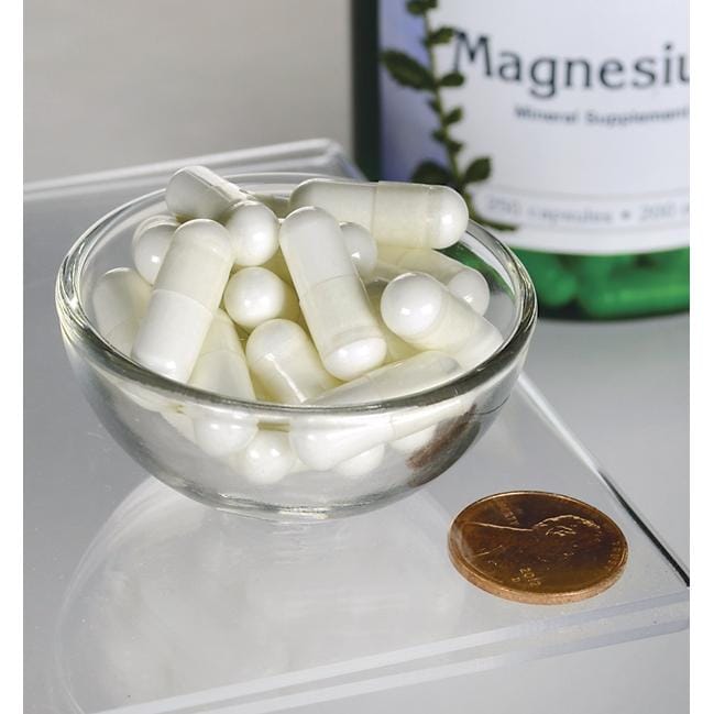 Eine Schale mit weißen Pillen neben einer Flasche Swanson Magnesiumoxid - 200 mg 250 Kapseln.