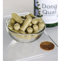 Vorschaubild für Swanson Dong Quai - 530 mg 100 Kapseln in einer Schale neben einer Flasche.