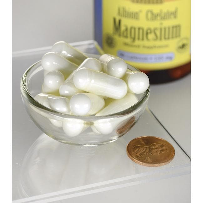 Albion Chelated Magnesium Glycinate supplements by Swanson in a glass bowl next to a bottle and a penny for scale, aimed at improving muscle health.