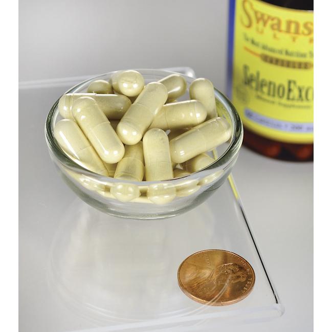 Eine Flasche Swanson's SelenoExcell Selen - 200 mcg 60 Kapseln Nahrungsergänzungsmittel und ein Penny neben einer Schale mit Pillen, die für Herz-Kreislauf-Pflege werben.