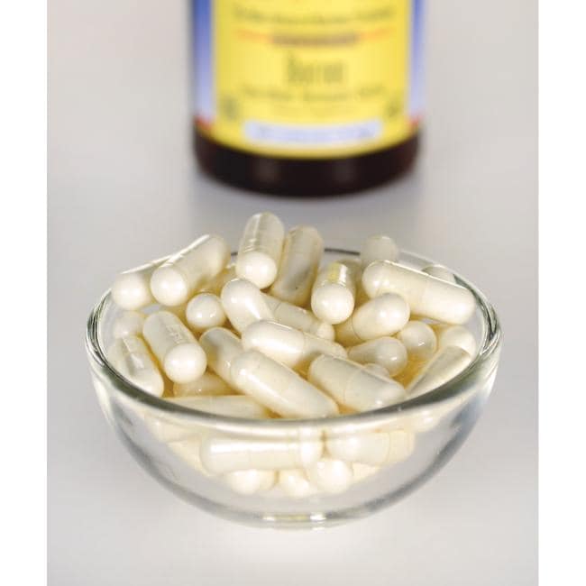 Swanson Albion Bor Bororganic Glycine - 6 mg 60 Kapseln in einer Schale neben einer Flasche mit Vitamin C.