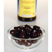 Thumbnail for Swanson's Vitamin K2 - MK-7 - 100 mcg 30 softgels, known for their high vitamin K2 content, are elegantly displayed in a glass bowl alongside a bottle of nutritious olive oil. This combination promotes healthy bones and helps prevent