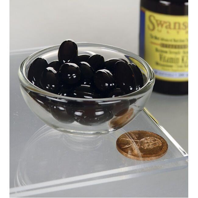 Black olives in a glass bowl next to a penny, promoting healthy bones with Swanson's Vitamin K2 - MK-7 - 200 mcg 30 softgels Real Food content.