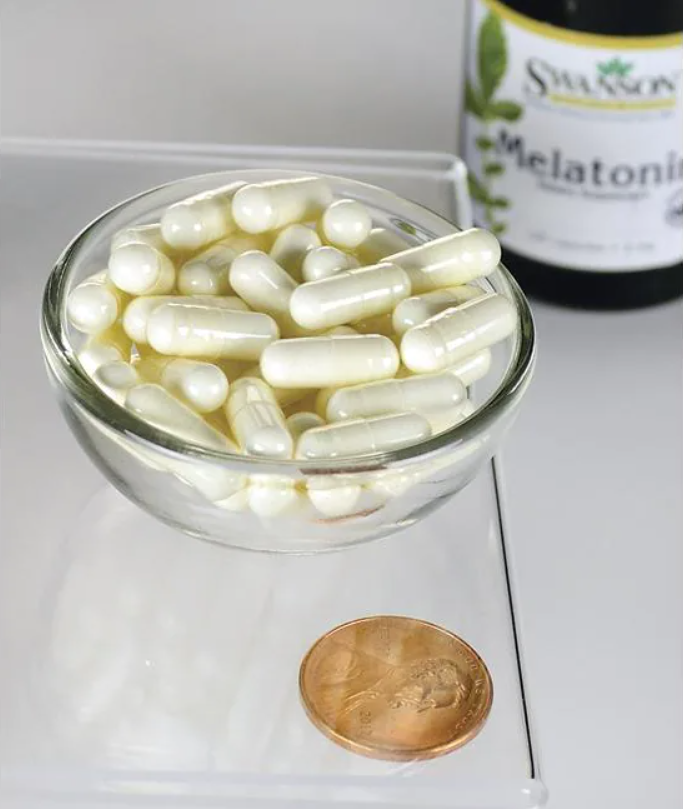 Eine Schale mit Swanson Melatonin - 3 mg 120 Kapseln neben einem Pfennig.
