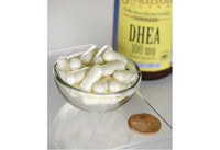 Vorschaubild für Swanson DHEA - 100 mg 60 Kapseln in einer Schale neben einem Pfennig.